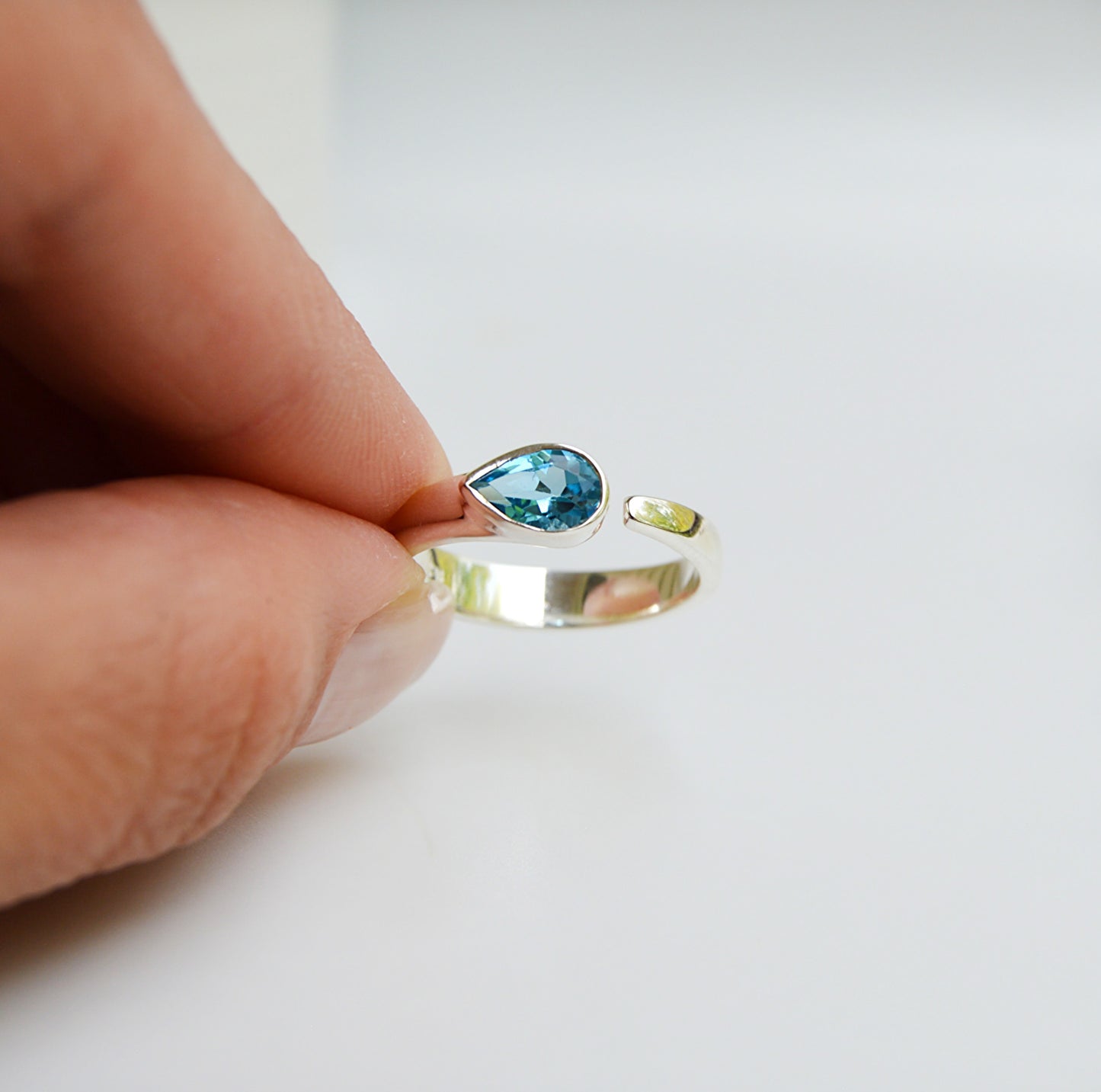 JeniMarie Jewelry with a blue topaz tube set ring featuring an adjustable comfort band and set in .925 sterling silver.