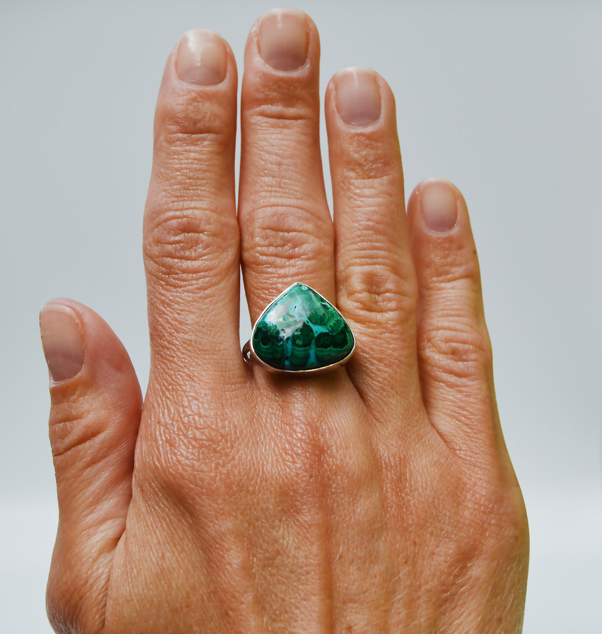 JeniMarie Jewelry with a statement ring featuring a forest green pear shaped one of a kind azurite and malachite stone. 