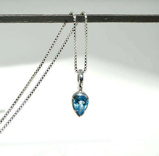 Necklace with a blue teardrop pendant on a white background
