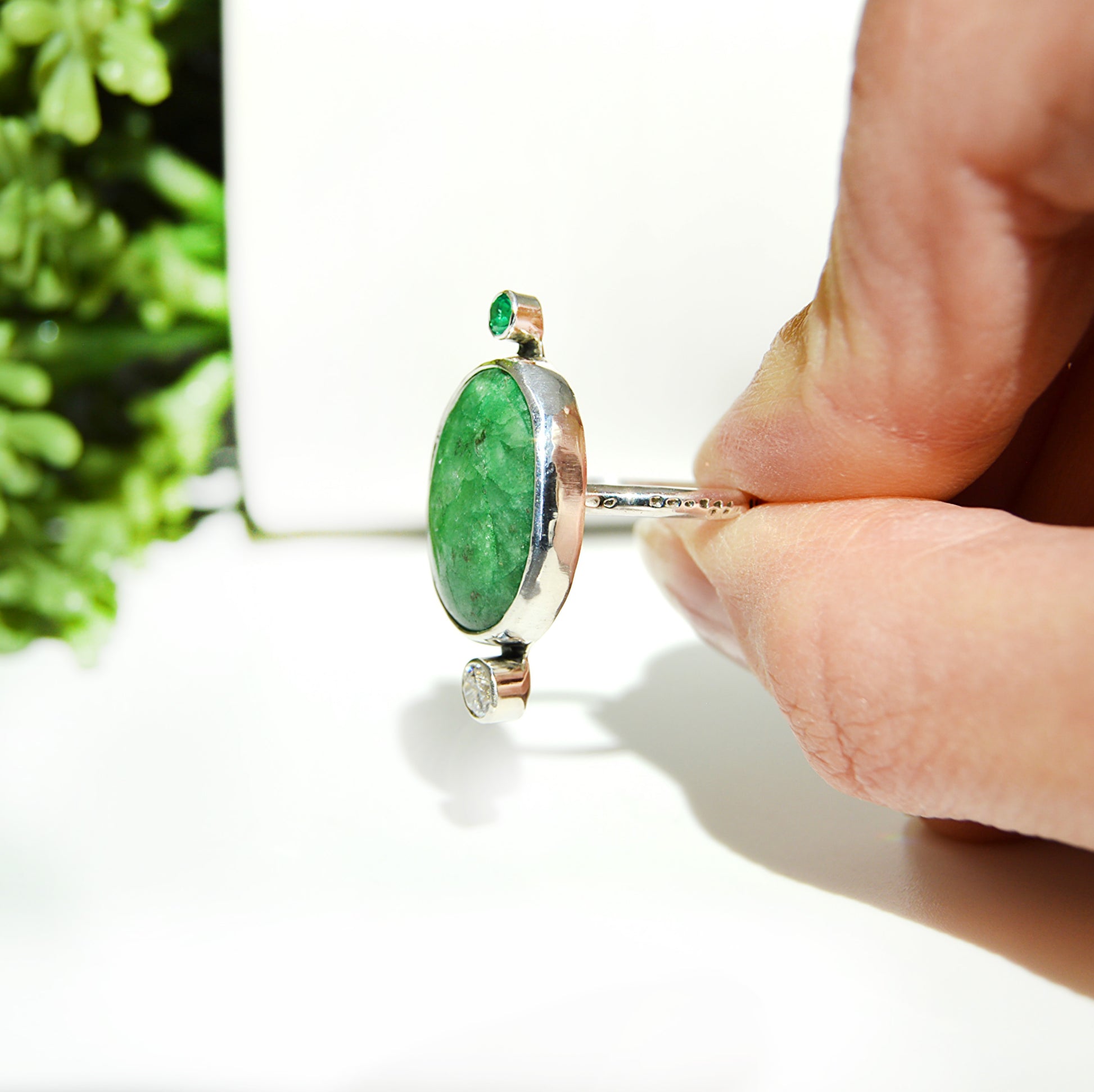 Oval green emerald quartz takes center stage on the custom ring. Using accented tube set stones to complete the piece. Both fine silver and sterling silver were used to make this beautiful ring. 