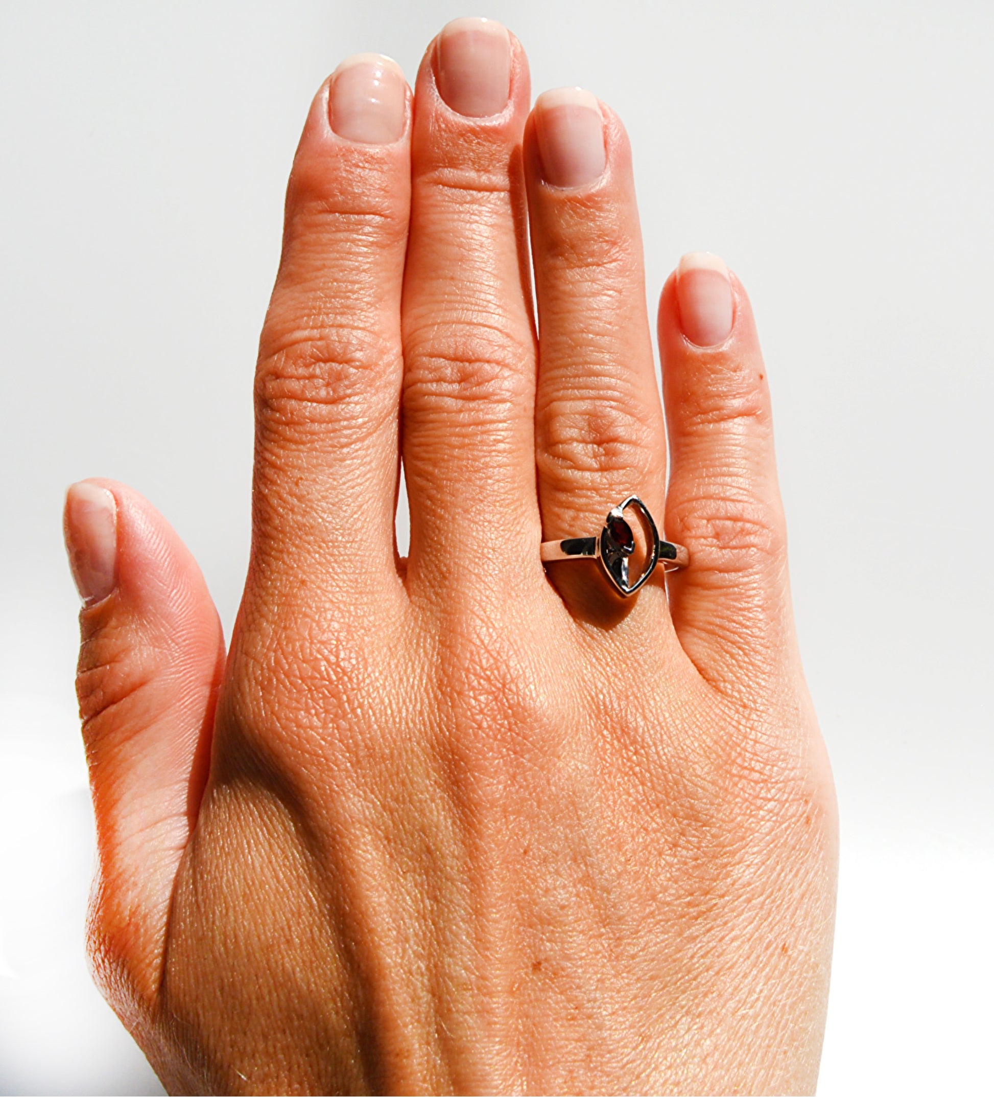 JeniMarie Jewelry with a statement ring featuring a red garnet stone and a comfort fit band all while having a unique setting. 