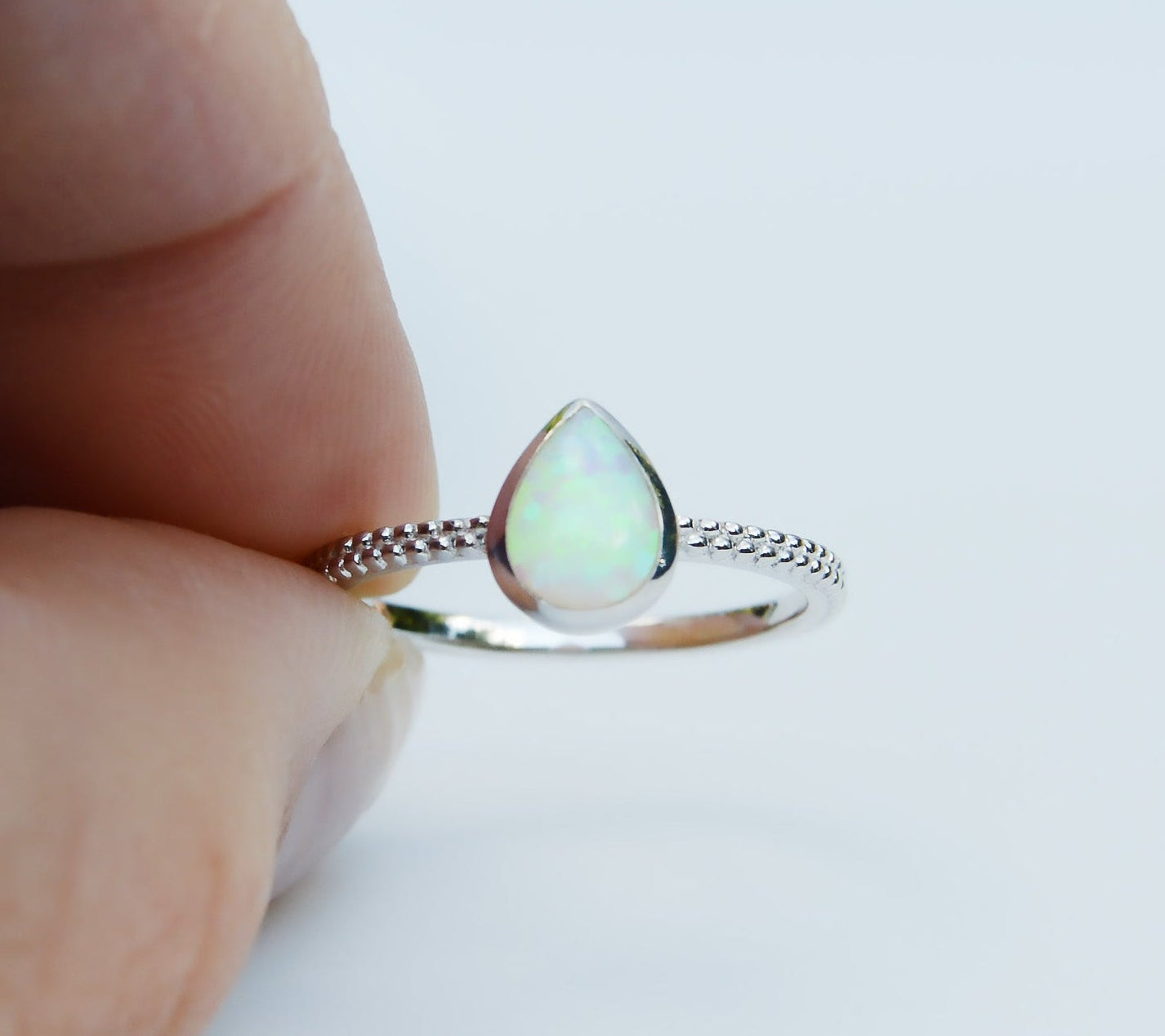 JeniMarie Jewelry with a stunning opal tear drop ring set in sterling silver featuring a textured band for added appeal. 