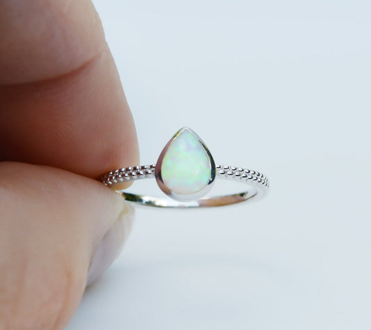 JeniMarie Jewelry with a stunning opal tear drop ring set in sterling silver featuring a textured band for added appeal. 