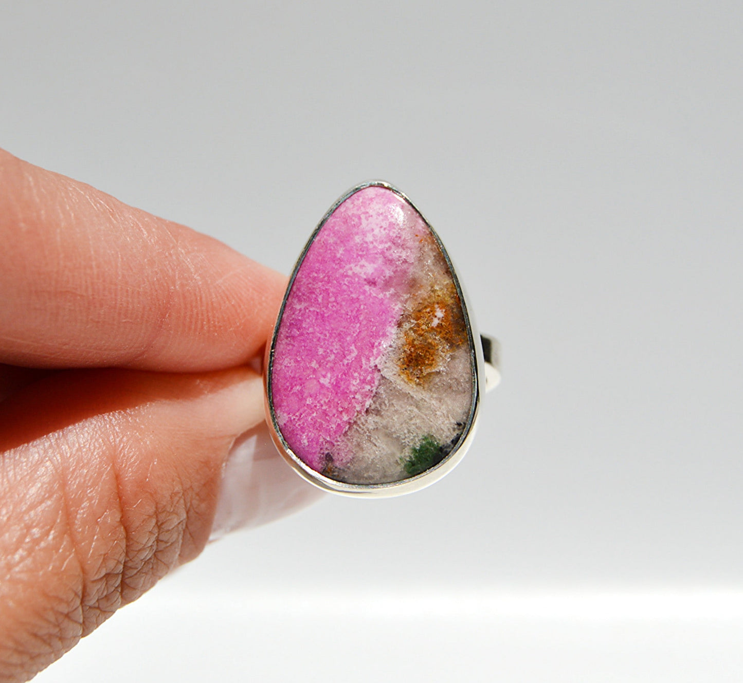 JeniMarie Jewelry with a pink druzy stone with an adjustable band for a comfort fit all set in sterling silver. 