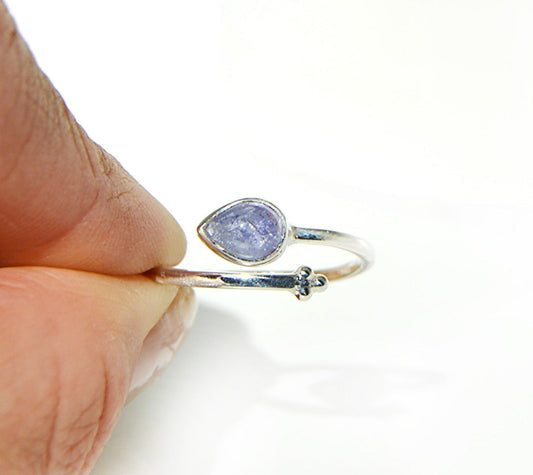 Silver ring with a teardrop-shaped blue gemstone held between fingers Handmade by JeniMarie Jewelry, single band ring hypoallergenic jewelry